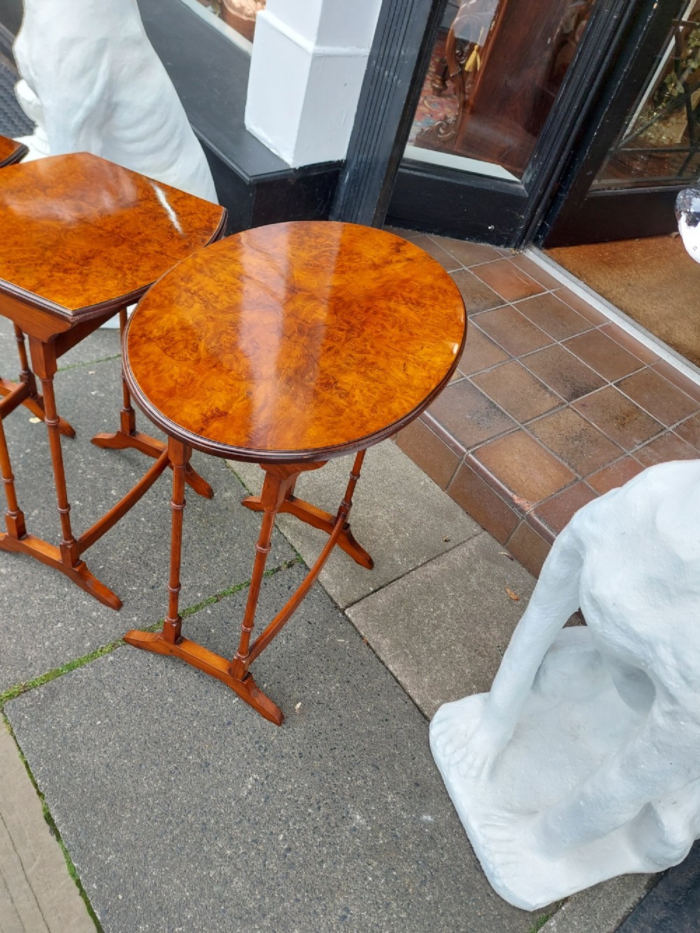 A set of three Edwardian nesting tables crafted from burr walnut with slender turned legs, stretcher supports, and shaped tops. View IV