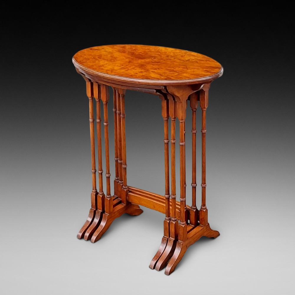A set of three Edwardian nesting tables crafted from burr walnut with slender turned legs, stretcher supports, and shaped tops. View V