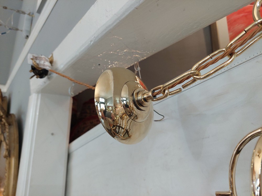 A hexagonal polished brass ceiling lantern with clear glass side panels, scrolled top canopy, and turned bottom finials. View IV