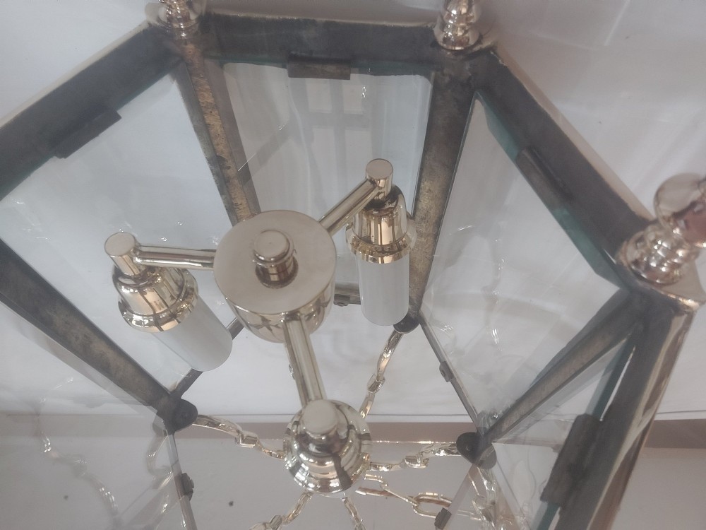 A hexagonal polished brass ceiling lantern with clear glass side panels, scrolled top canopy, and turned bottom finials. View VIII