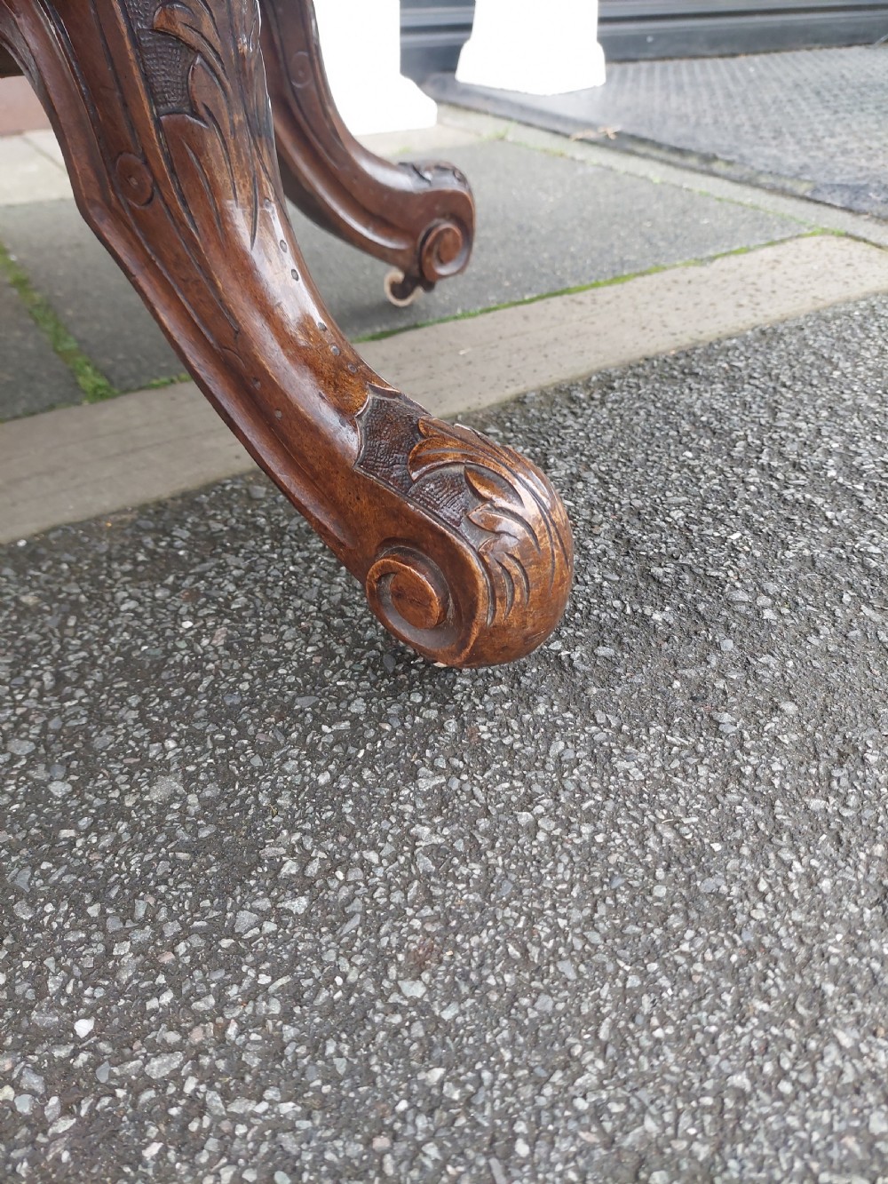 A low oval Victorian coffee table crafted from faded rosewood with a highly figured grain top and a carved pedestal base. View V