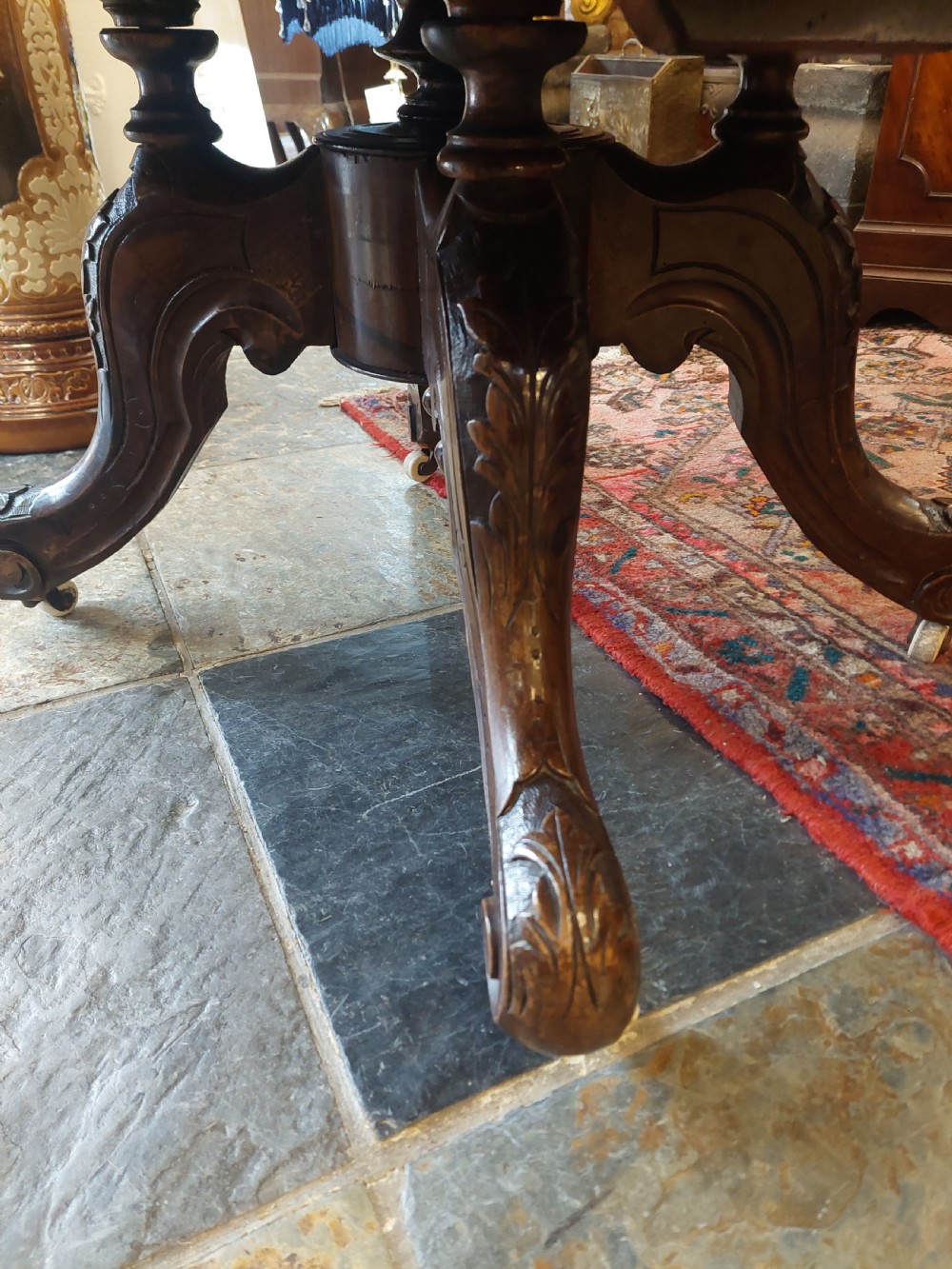 A low oval Victorian coffee table crafted from faded rosewood with a highly figured grain top and a carved pedestal base. View VIII