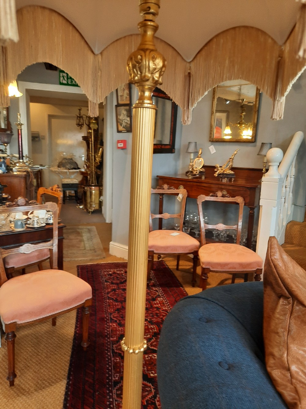 A three-piece antique lamp set featuring two tall standard lamps and one table lamp with ornate gilt cherub bases, alabaster spheres, and fringed cream domed shades. View IX