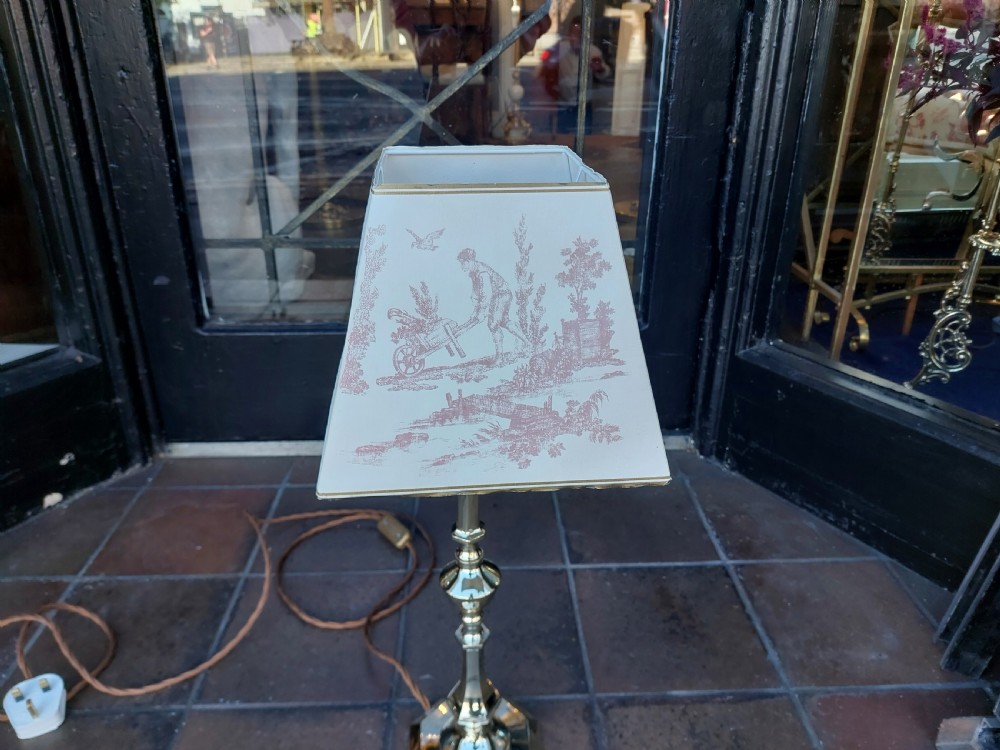 An Art Nouveau silvered brass table lamp featuring a hexagonal faceted stem and a white tapered shade printed with a pastoral scene. View II