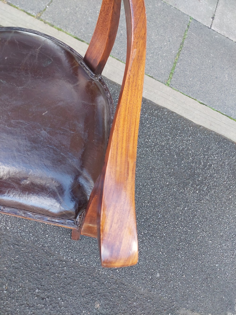 A 19th-century French elm desk chair featuring a curved backrest, sweeping armrests, and a dark leather upholstered seat. View V