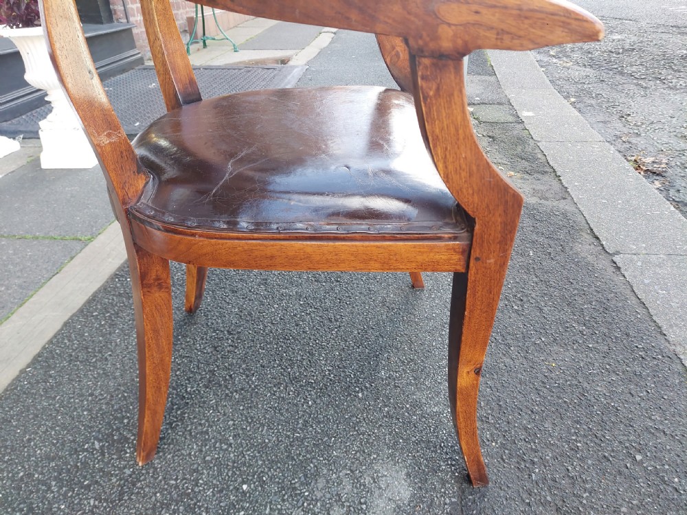 A 19th-century French elm desk chair featuring a curved backrest, sweeping armrests, and a dark leather upholstered seat. View VII