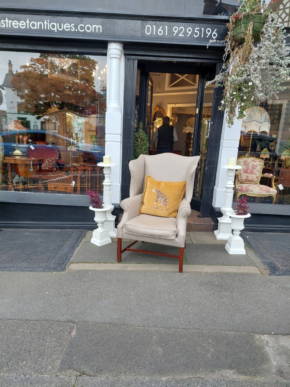 A Victorian wingback armchair upholstered in off-white leather with scrolled arms and dark mahogany legs connected by stretchers. View VIII