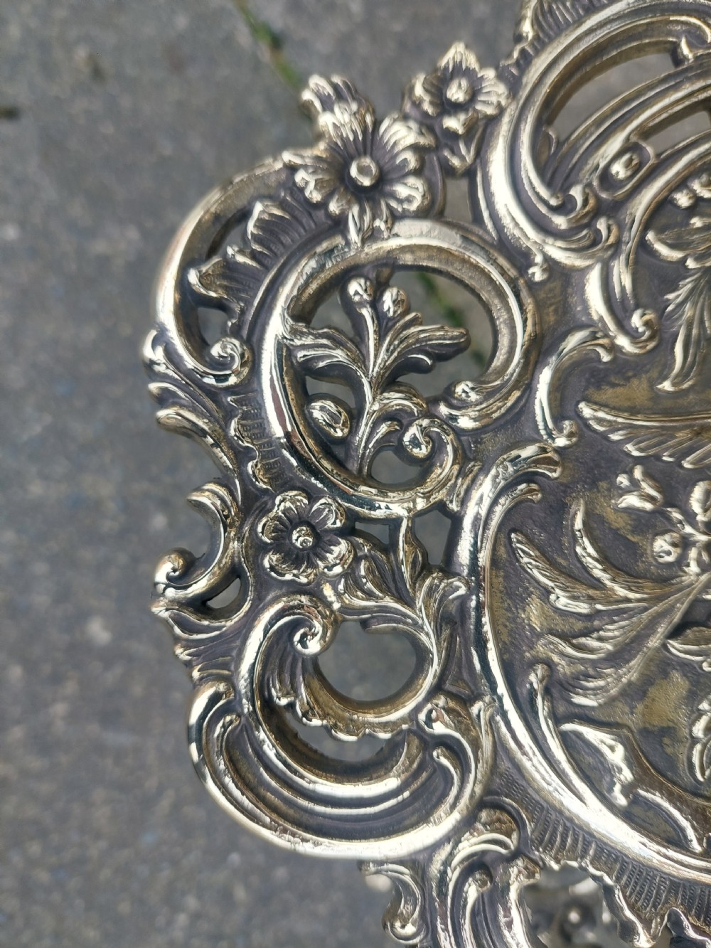 A Victorian three-tier brass stand featuring pierced fretwork platforms, vertical turned columns, and decorative scroll feet. View VI