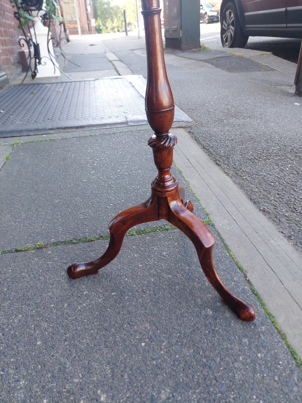 An Edwardian mahogany wine table featuring a polished circular top, turned central column, and three cabriole tripod legs. View IV