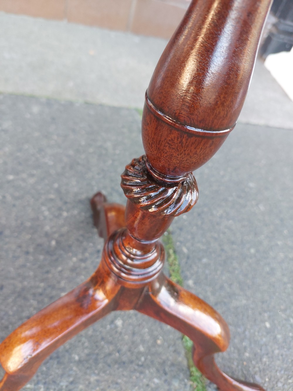 An Edwardian mahogany wine table featuring a polished circular top, turned central column, and three cabriole tripod legs. View VI