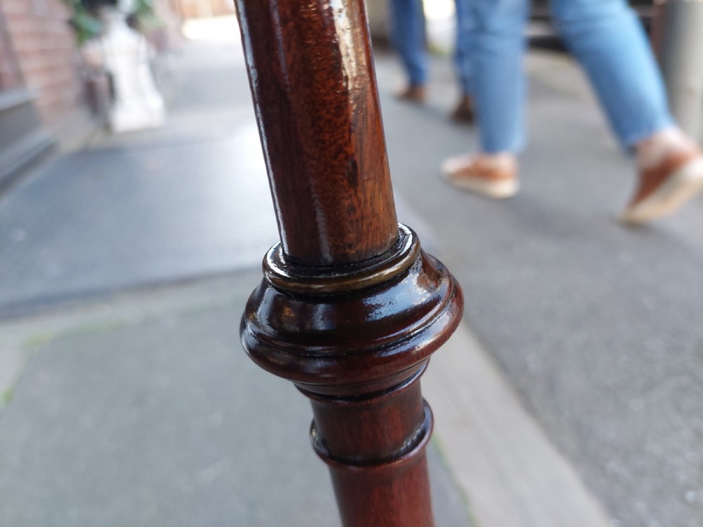 An Edwardian mahogany wine table featuring a polished circular top, turned central column, and three cabriole tripod legs. View VIII