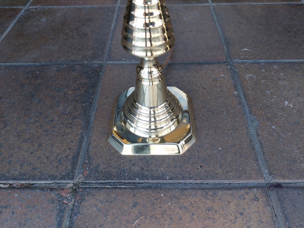 A pair of turned brass Edwardian candlestick table lamps fitted with white pleated lampshades. View II