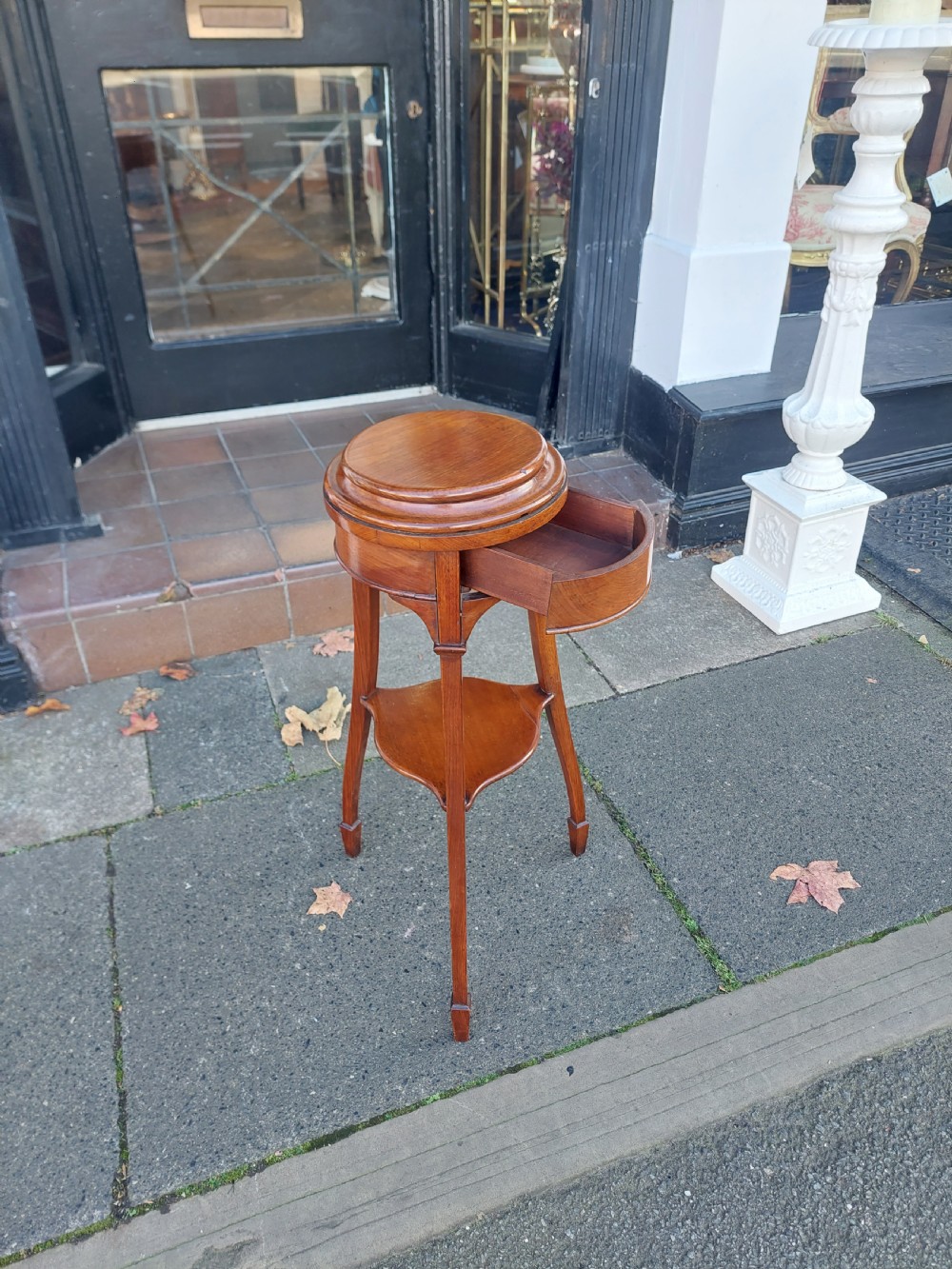 An Edwardian circular walnut vase stand with slender splayed legs and a lower triangular tier. View VI