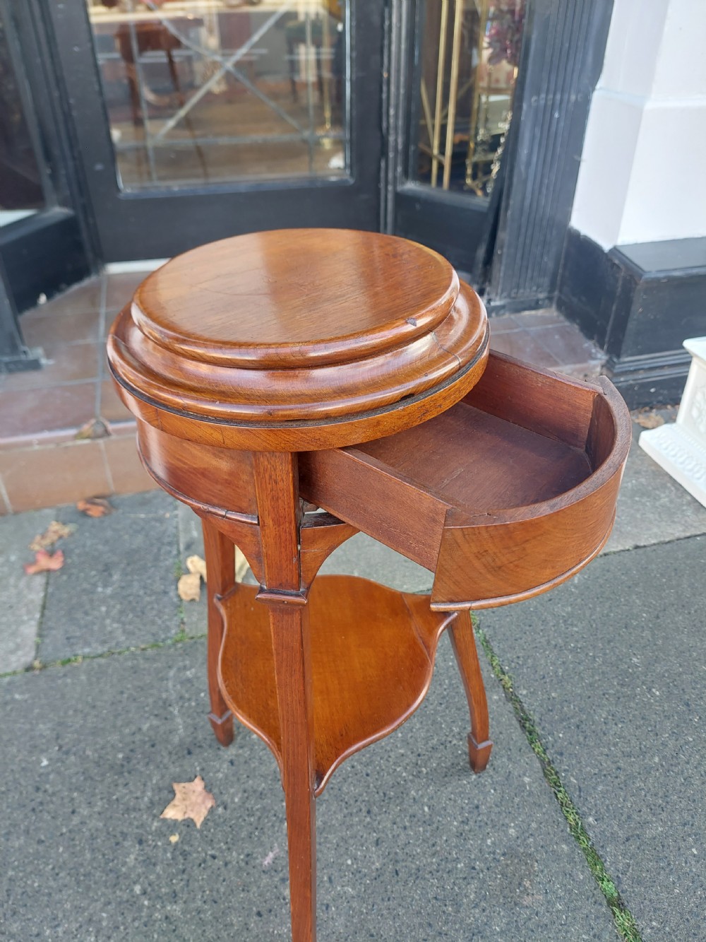 An Edwardian circular walnut vase stand with slender splayed legs and a lower triangular tier. View VII