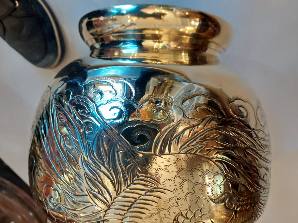 A rounded polished brass Japanese jardiniere with hand-chased relief dragons and clouds, resting on a stepped base. View VII