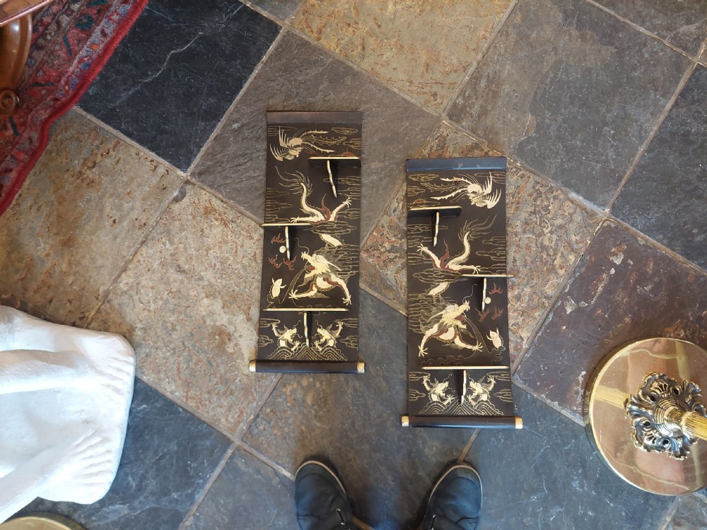 A pair of black lacquered wall shelves featuring scroll end caps and hand-painted gilt dragon and phoenix motifs with stepped display brackets. View III