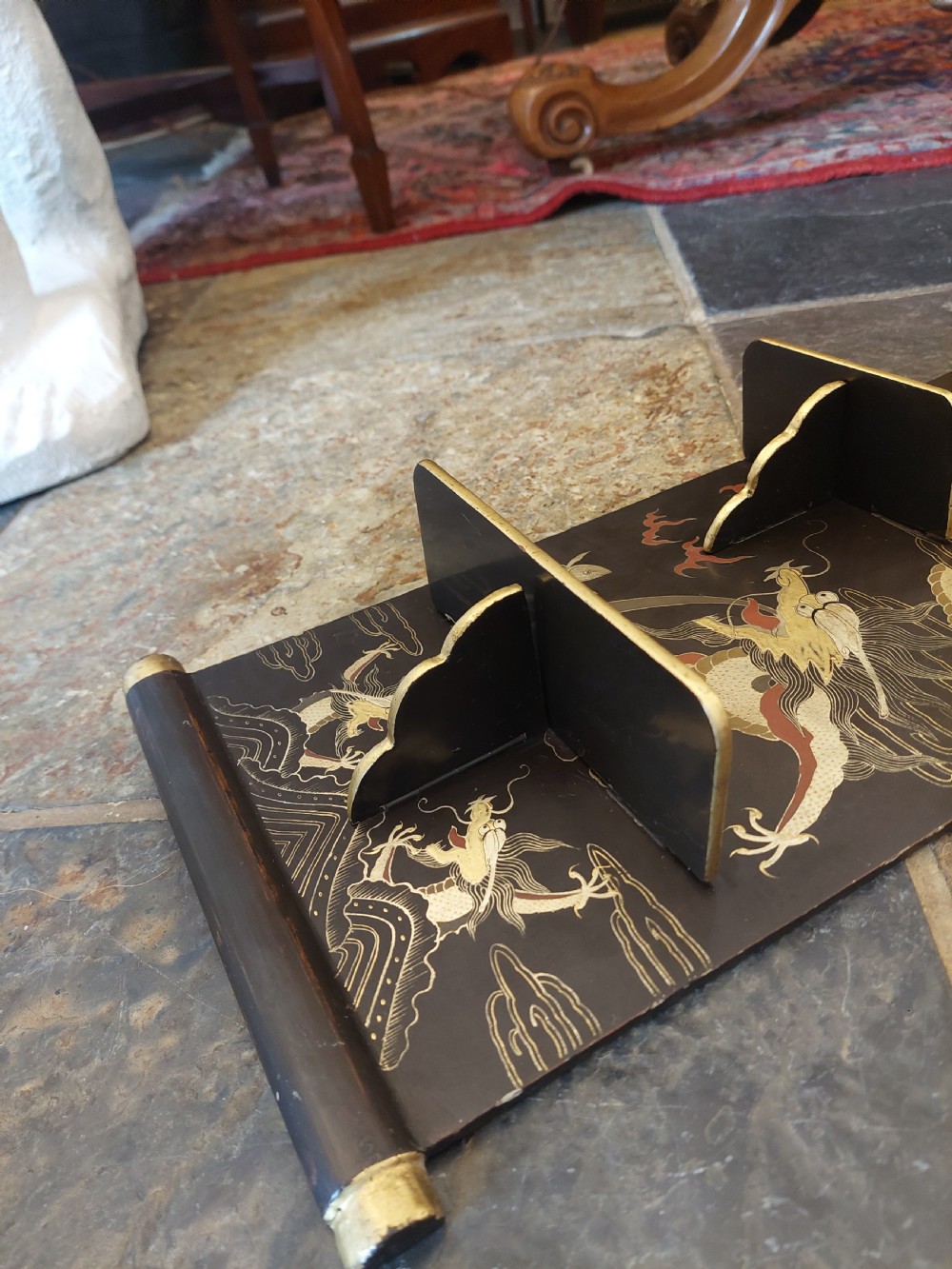 A pair of black lacquered wall shelves featuring scroll end caps and hand-painted gilt dragon and phoenix motifs with stepped display brackets. View IV