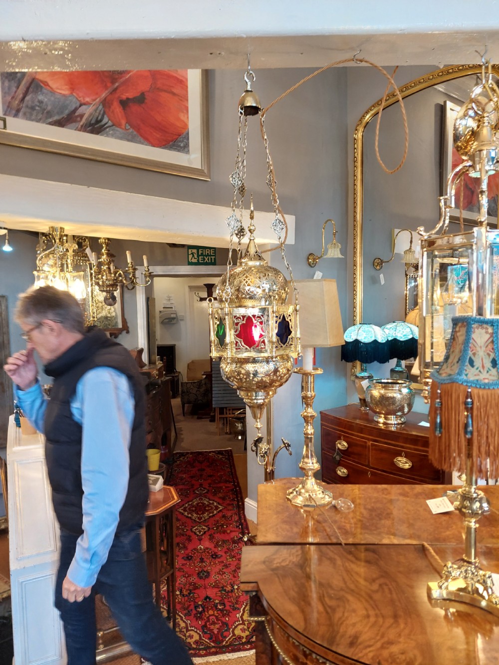 A hanging polished brass lantern featuring intricate pierced fretwork, dark glass insert panels, and three suspension chains topped with a crescent moon motif. View XIII