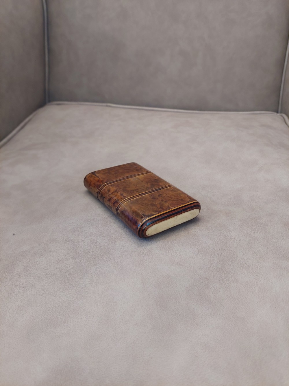 A late nineteenth-century pocket cigar case made from burr walnut with inlaid line detailing, shown partially open to reveal cigars inside. View II