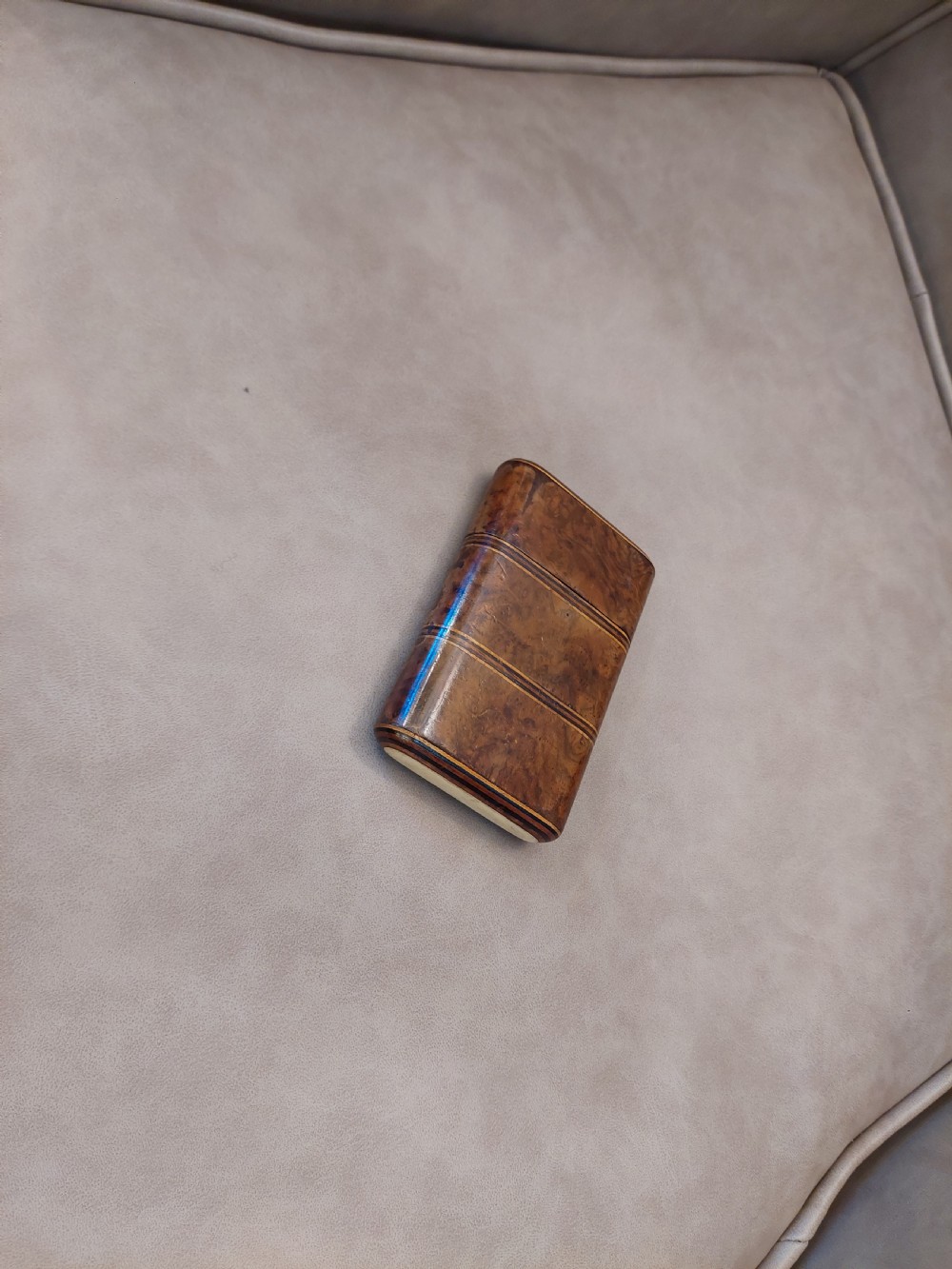 A late nineteenth-century pocket cigar case made from burr walnut with inlaid line detailing, shown partially open to reveal cigars inside. View III