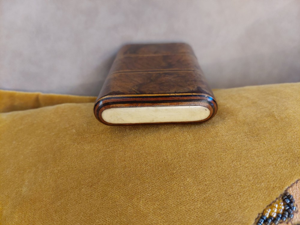 A late nineteenth-century pocket cigar case made from burr walnut with inlaid line detailing, shown partially open to reveal cigars inside. View VII
