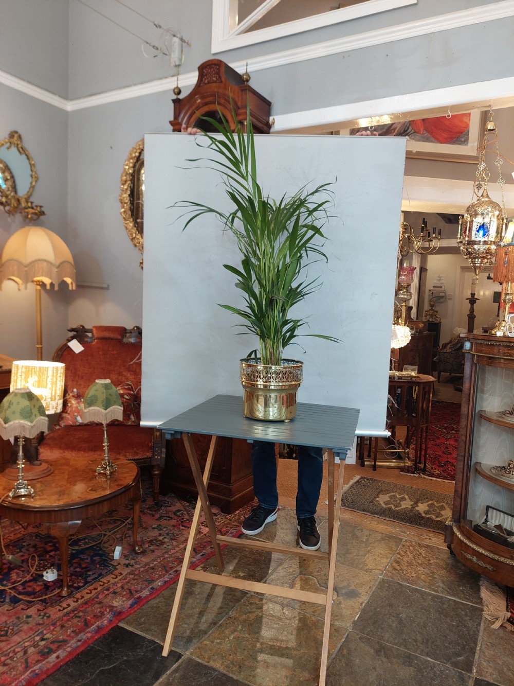 A cylindrical polished brass planter featuring a decorative pierced fretwork border near the upper rim and raised on small feet. View VI