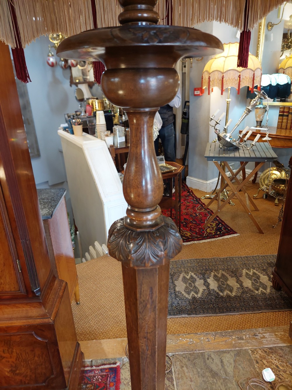 A matched pair of turned dark oak standard lamps featuring ornate burgundy and cream patterned fabric shades with tassel fringe. View VII