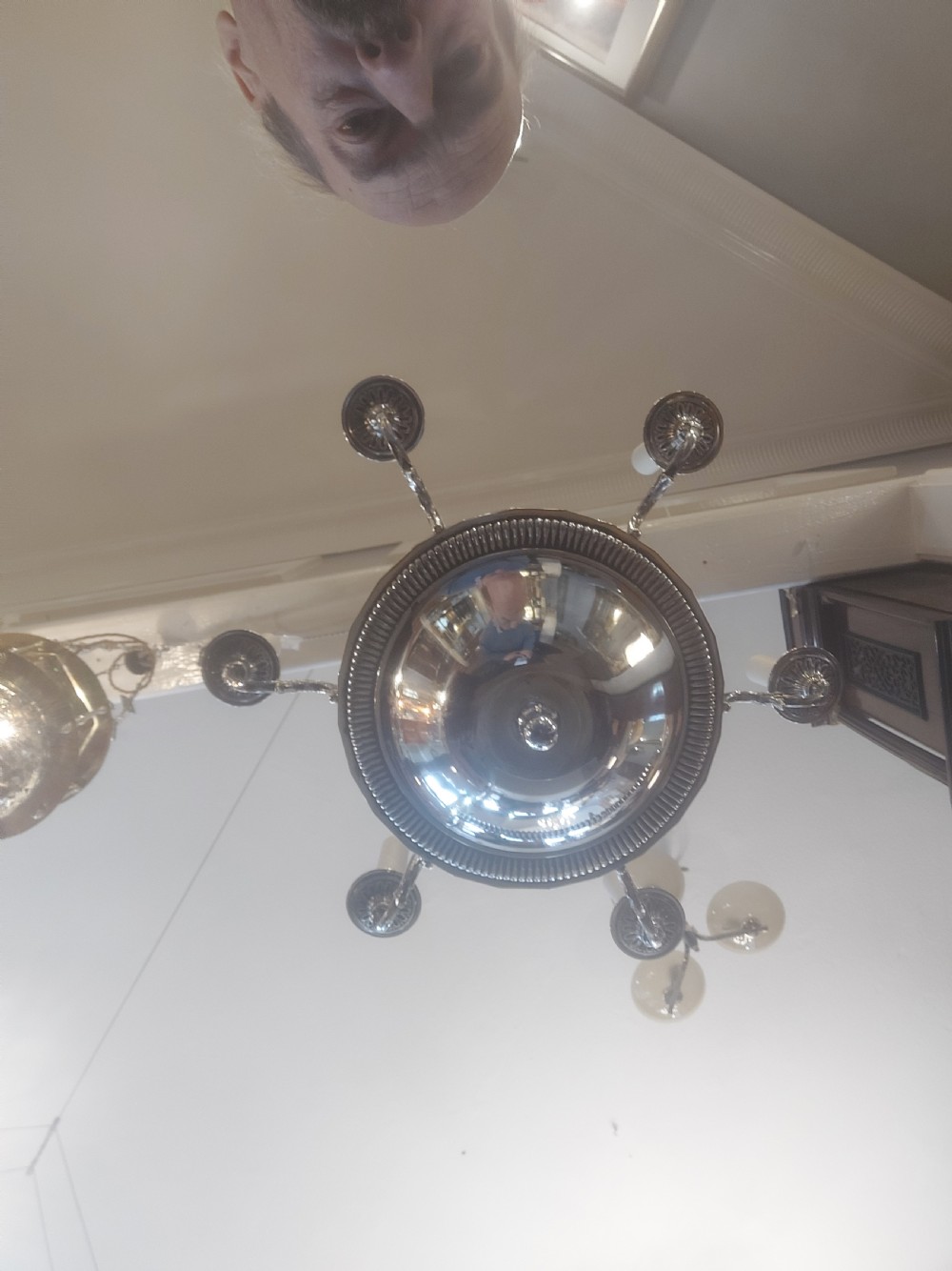 An early twentieth-century silver-plated six-arm ceiling chandelier featuring candle-style light sockets and a central fluted column. View II