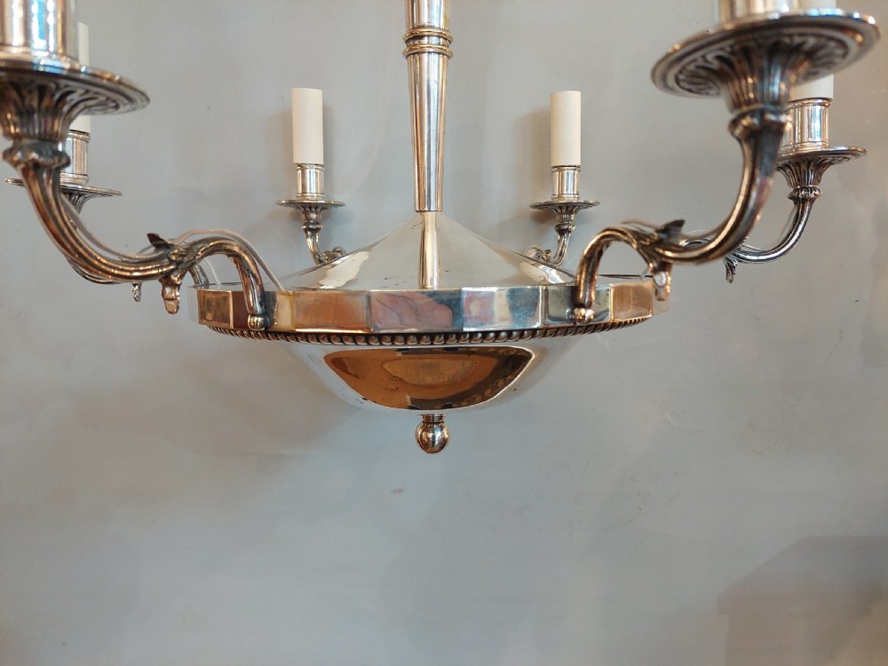 An early twentieth-century silver-plated six-arm ceiling chandelier featuring candle-style light sockets and a central fluted column. View VIII