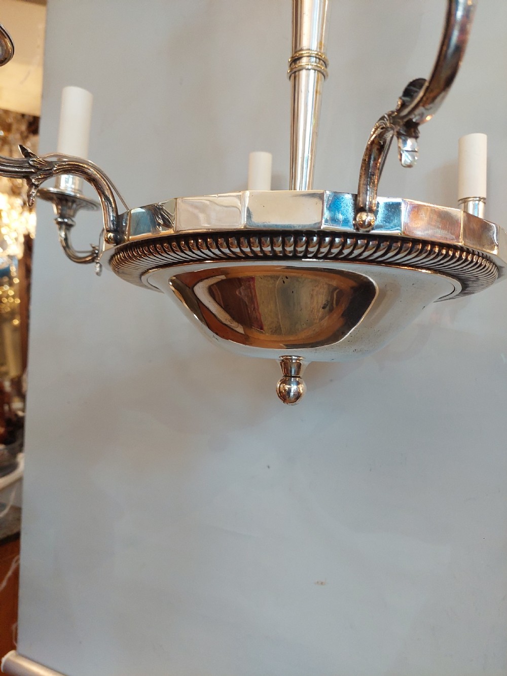 An early twentieth-century silver-plated six-arm ceiling chandelier featuring candle-style light sockets and a central fluted column. View X