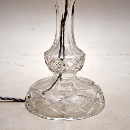 fig 1. A clear cut crystal table lamp featuring a domed glass shade supported by brass scroll arms above a facetted glass stem and circular base.