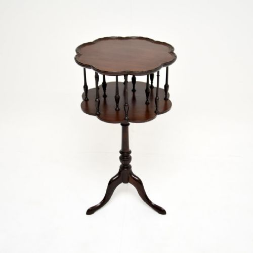 fig 1. An antique dark mahogany occasional table featuring a scalloped rim, turned spindles surrounding a lower tier, and a central pedestal resting on tripod cabriole legs.