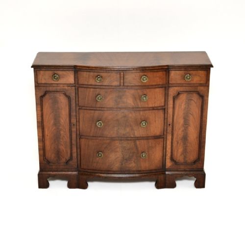 fig 1. A Georgian style mahogany breakfront sideboard featuring central drawers, flanking side cupboards, brass ring handles, and shaped bracket feet.