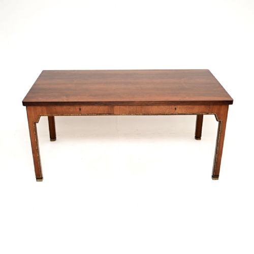 fig 1. A rectangular mid-century Danish rosewood writing desk featuring shallow frieze drawers, inlaid decorative trim along the apron, and straight legs with metal sabots.