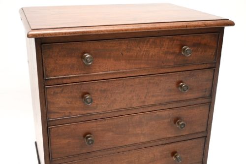 fig 1. An antique Georgian mahogany chest featuring four graduated drawers with turned knobs, resting on shaped bracket feet.