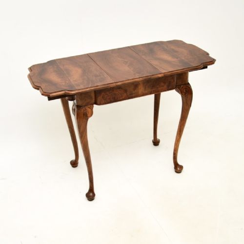 fig 1. A figured walnut occasional side table featuring a shaped top with veneer grain, a deep apron, and slender cabriole legs ending in pad feet.