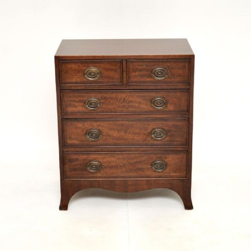fig 1. An antique mahogany chest of drawers featuring string inlay borders, five drawers with oval brass handles, and splayed bracket feet.