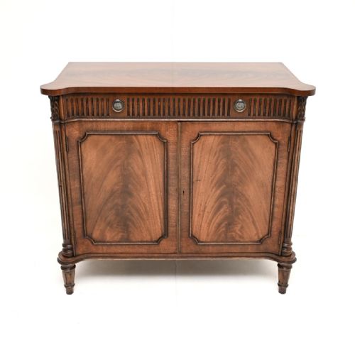 fig 1. An antique flame mahogany two-door side cabinet featuring fluted corner columns, circular brass handles, and turned reeded legs.