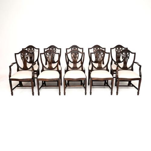 fig 1. A set of ten dark mahogany shield back dining chairs with carved central splats and cream upholstered seats.