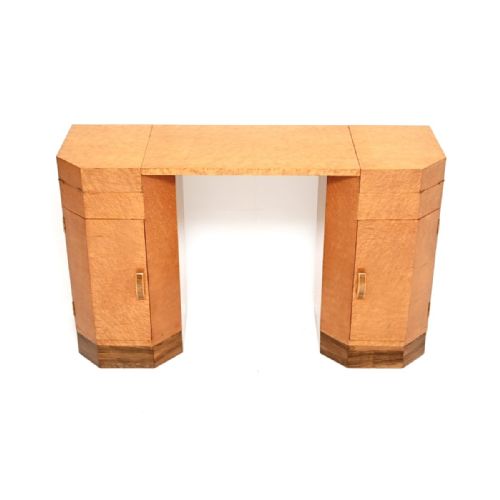 fig 1. An Art Deco birdseye maple dressing table featuring twin pedestals with fold-out top trays, lower cupboards, and a contrasting dark wood plinth base.