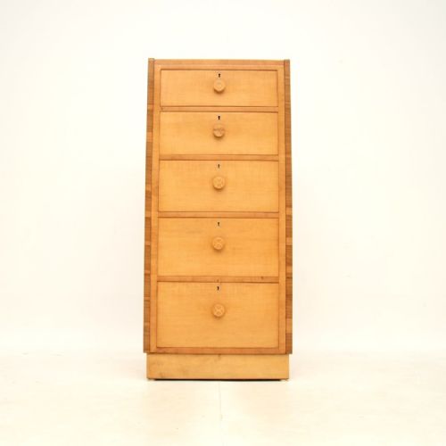 fig 1. An Art Deco light sycamore tallboy chest of drawers featuring five drawers with circular wooden knobs and dark timber side crossbanding.