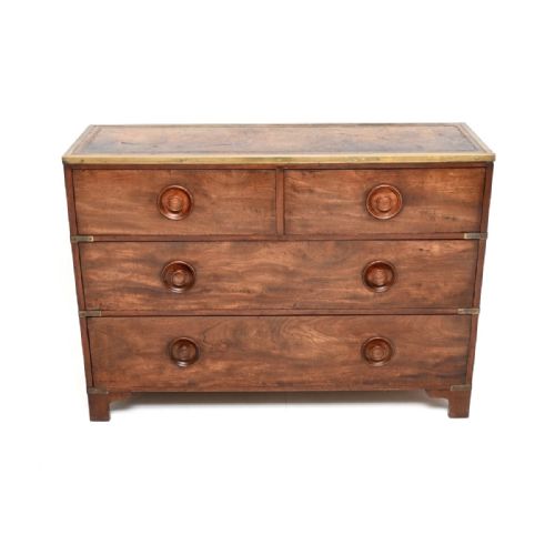 fig 1. An antique mahogany military campaign chest featuring brass corner brackets, a leather inset top, and turned wooden knobs.