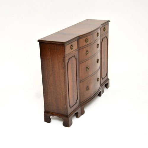 fig 1. A Georgian style mahogany breakfront sideboard featuring a central drawer stack, side cupboards, brass ring handles, and bracket feet.