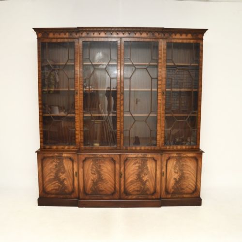 fig 1. A large Georgian style mahogany breakfront bookcase featuring upper glazed doors with geometric astragal glazing and flame mahogany panelled doors on the lower section.