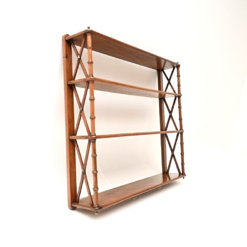 fig 1. A Georgian period wall-mounted walnut bookcase featuring four open shelves, x-frame sides, and turned spindle supports.