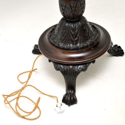 fig 1. An antique Victorian carved mahogany standard lamp featuring a carved tripod base, turned column, and a light fabric shade with fringed edging.