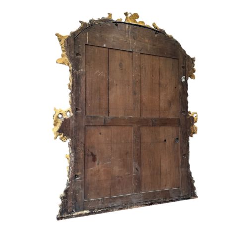 fig 1. An 18th-century Italian giltwood mirror with an arched top and an intricately carved frame detailing grapevines and cluster motifs.