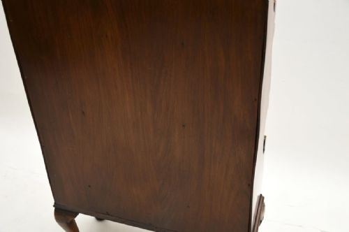 fig 1. An antique burr walnut open bookcase with three cascading shelves, two lower drawers with drop handles, and cabriole legs.
