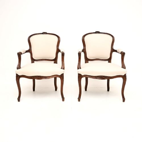 fig 1. A pair of French Louis XV style carved walnut salon armchairs upholstered in cream fabric with cabriole legs.