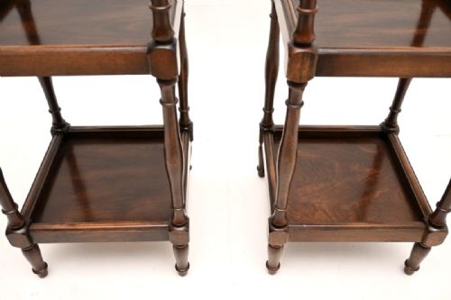 fig 1. A matching pair of three-tier dark mahogany side tables with turned spindle supports and brass finials on the top corners.